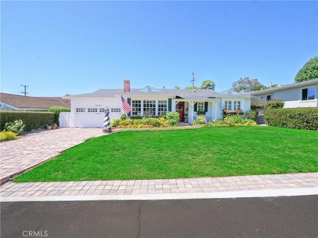 single story home featuring a garage and a front lawn