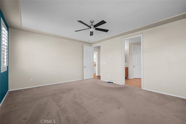 unfurnished bedroom with ceiling fan, light colored carpet, and ensuite bathroom