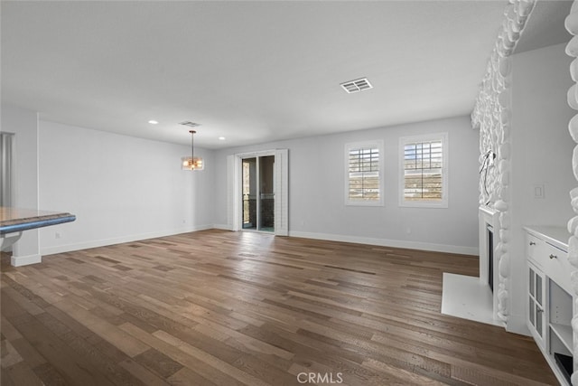 unfurnished living room with dark hardwood / wood-style floors and a chandelier