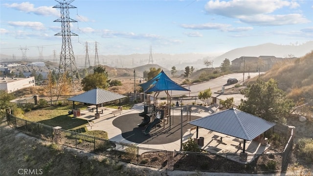 view of patio featuring a playground, a gazebo, and a mountain view