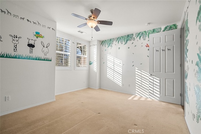 carpeted spare room with ceiling fan