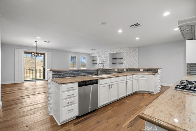 kitchen featuring white cabinetry, sink, hanging light fixtures, stainless steel appliances, and a center island with sink