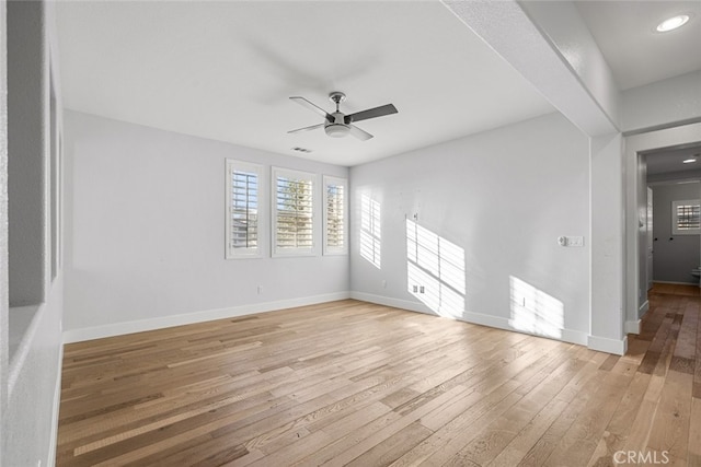 empty room with ceiling fan and light hardwood / wood-style flooring