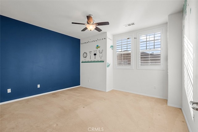 carpeted spare room featuring ceiling fan