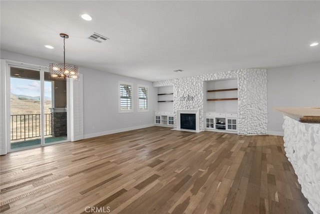 unfurnished living room with hardwood / wood-style floors and a chandelier