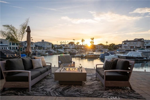 exterior space featuring a water view and an outdoor fire pit