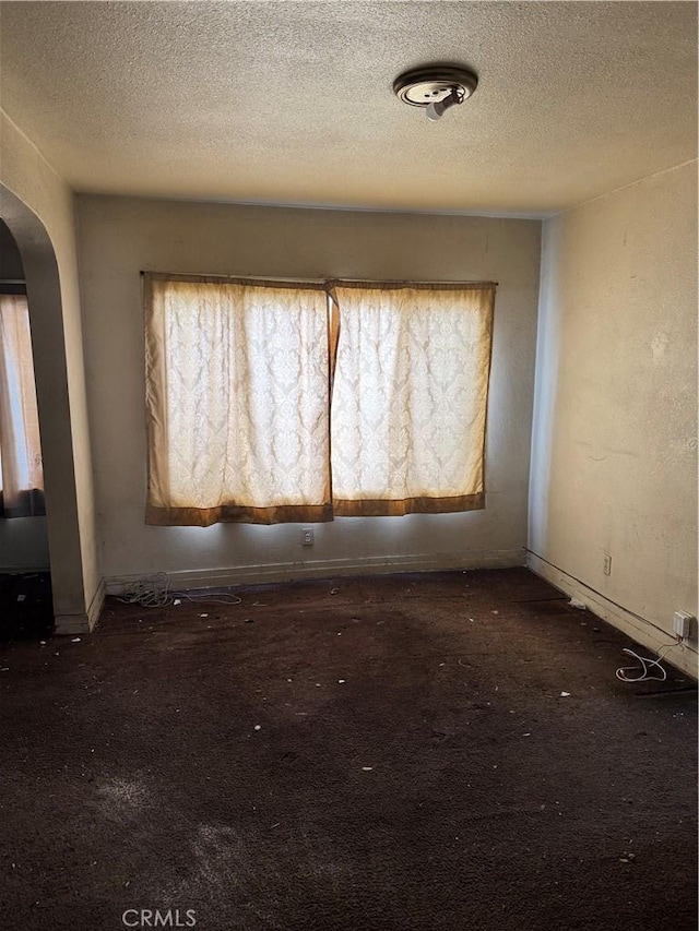 unfurnished room with a textured ceiling