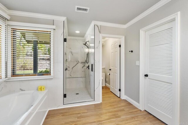 bathroom with crown molding, shower with separate bathtub, and hardwood / wood-style floors