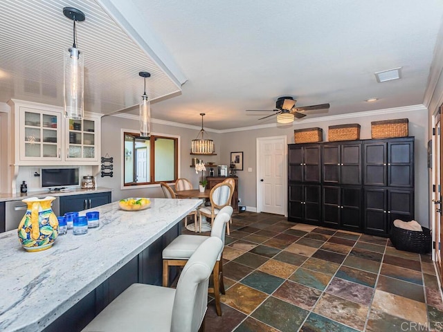 kitchen with a breakfast bar, decorative light fixtures, white cabinets, light stone countertops, and blue cabinetry