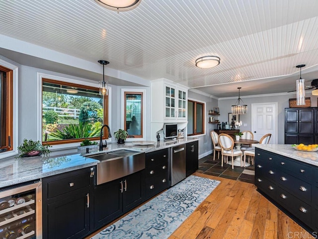 kitchen featuring wine cooler, sink, white cabinetry, pendant lighting, and hardwood / wood-style floors