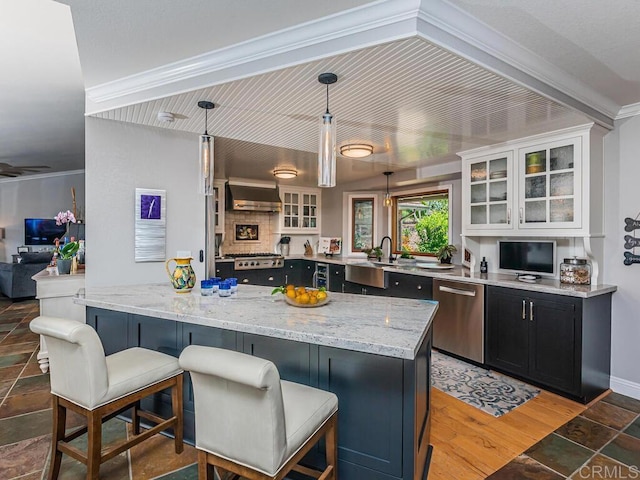 kitchen featuring white cabinetry, decorative light fixtures, dishwasher, and a breakfast bar area