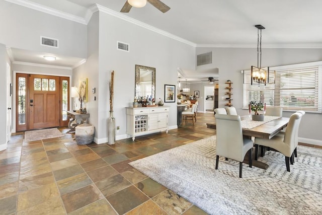 dining space with crown molding, ceiling fan with notable chandelier, and high vaulted ceiling