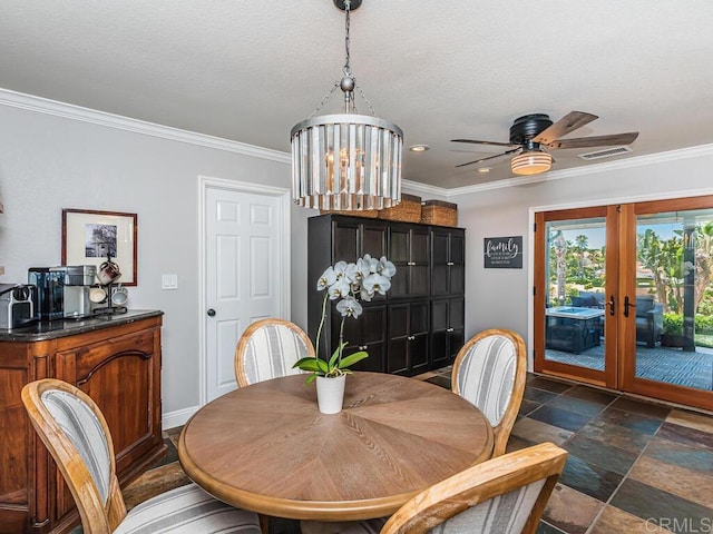 dining area featuring french doors, ornamental molding, ceiling fan with notable chandelier, and a textured ceiling