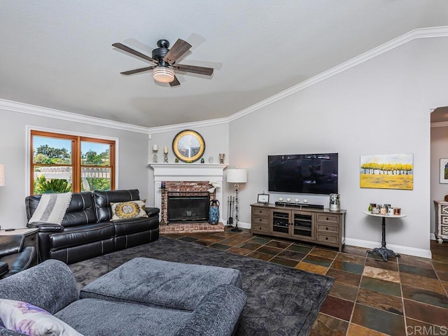 living room with lofted ceiling, a brick fireplace, ornamental molding, and ceiling fan