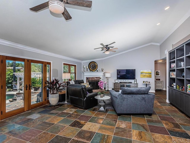 living room featuring lofted ceiling, ceiling fan, ornamental molding, a brick fireplace, and french doors