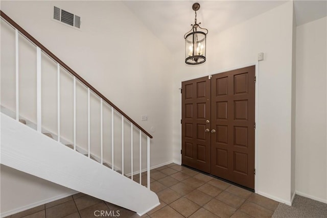 tiled entryway featuring a chandelier