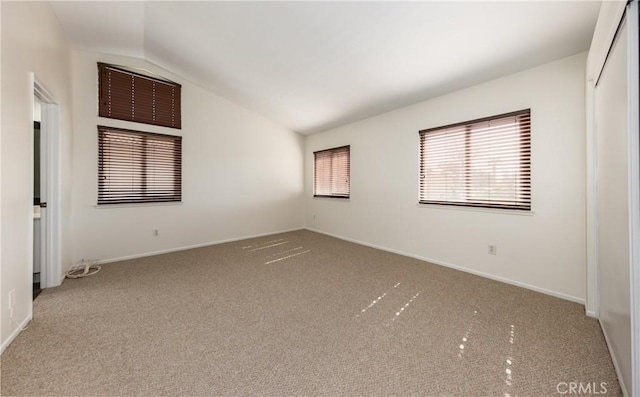 unfurnished bedroom featuring vaulted ceiling and carpet