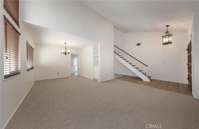 unfurnished living room with an inviting chandelier, built in features, high vaulted ceiling, and carpet