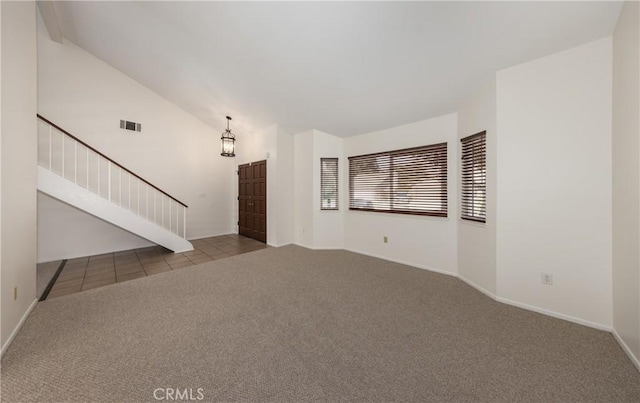 unfurnished living room with light colored carpet and high vaulted ceiling