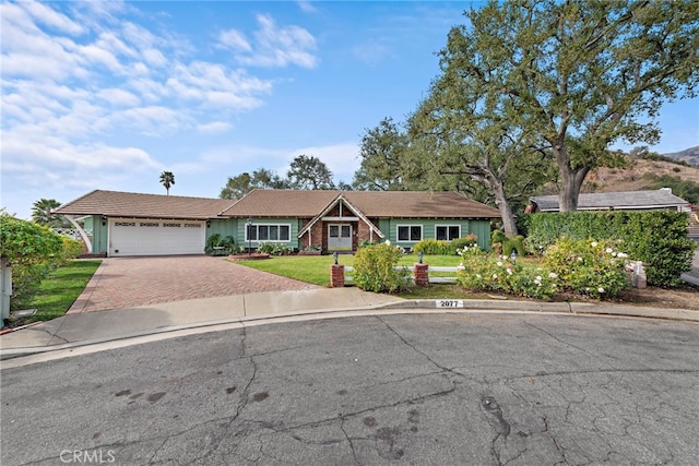 single story home featuring a garage and a front lawn