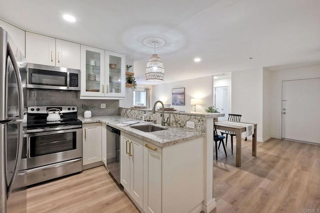 kitchen featuring white cabinetry, sink, stainless steel appliances, and kitchen peninsula