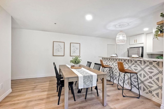 dining space with light wood-type flooring