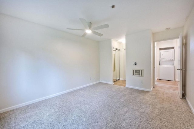 interior space featuring ceiling fan and stacked washer and clothes dryer