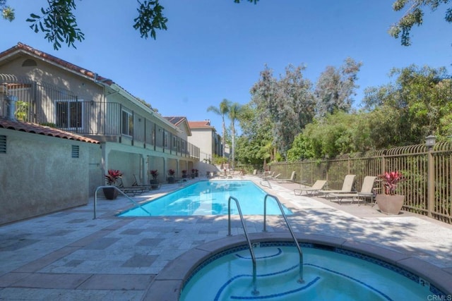 view of pool featuring a community hot tub and a patio