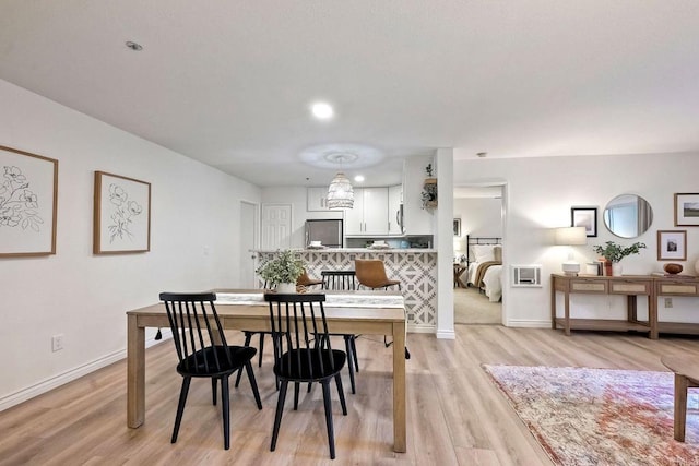 dining area featuring baseboards and light wood finished floors