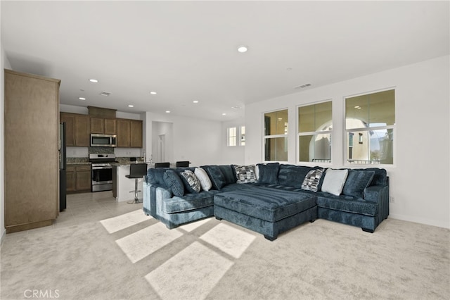 living area with recessed lighting, visible vents, and light colored carpet