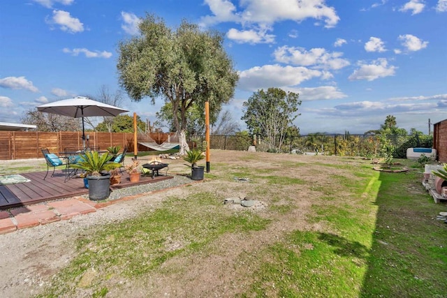 view of yard featuring a wooden deck and an outdoor fire pit