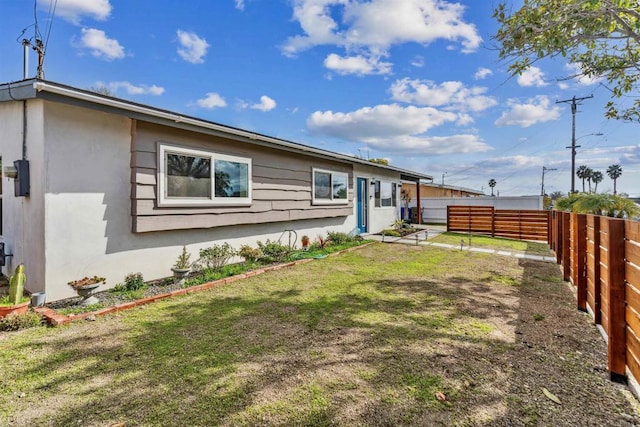 rear view of property featuring a lawn