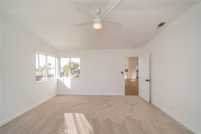 empty room with ceiling fan, light colored carpet, and vaulted ceiling