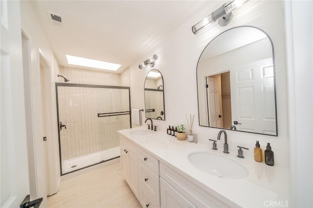 bathroom featuring vanity, a skylight, and a tile shower