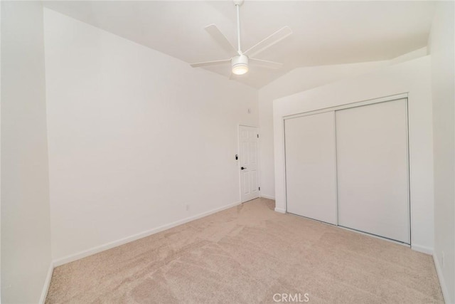 unfurnished bedroom with lofted ceiling, light colored carpet, ceiling fan, and a closet