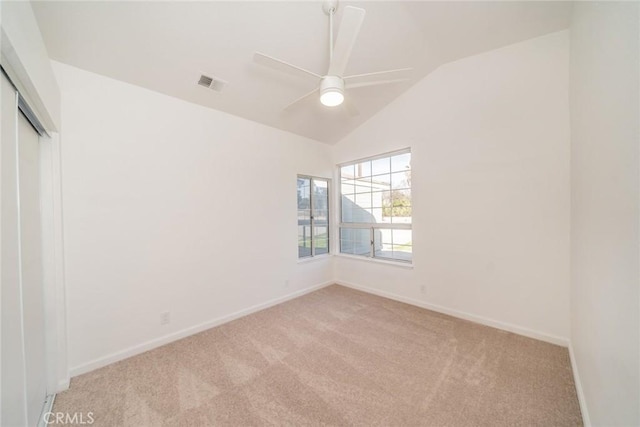 unfurnished bedroom featuring vaulted ceiling, light colored carpet, ceiling fan, and a closet