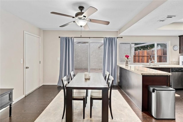 dining room featuring dark wood-type flooring, sink, and ceiling fan