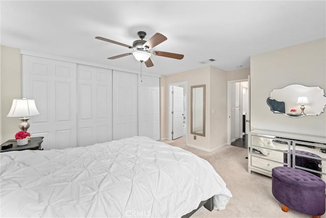 carpeted bedroom with ceiling fan and a closet