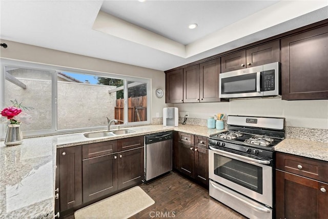 kitchen featuring stainless steel appliances, light stone countertops, and sink