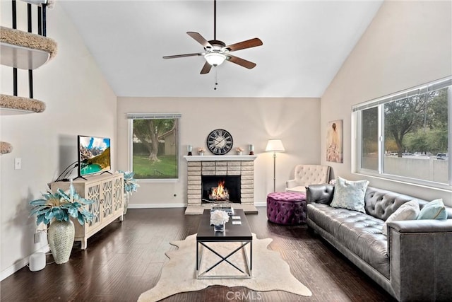 living room with ceiling fan, dark hardwood / wood-style flooring, high vaulted ceiling, and a brick fireplace