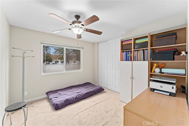 carpeted bedroom featuring ceiling fan and a closet