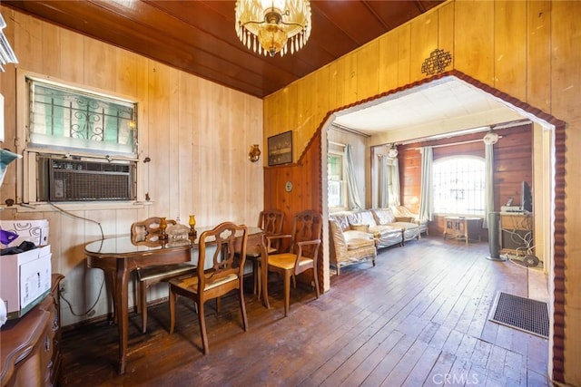 living area with wooden walls, cooling unit, wooden ceiling, and dark hardwood / wood-style flooring