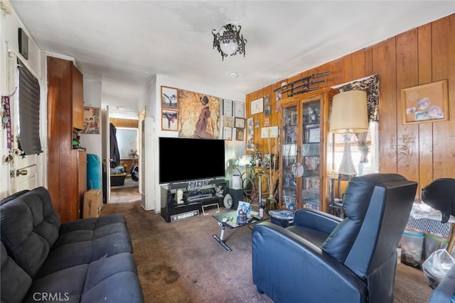 living room with wooden walls and dark colored carpet