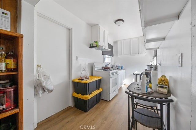 kitchen featuring white cabinetry, white gas range, and light wood-type flooring