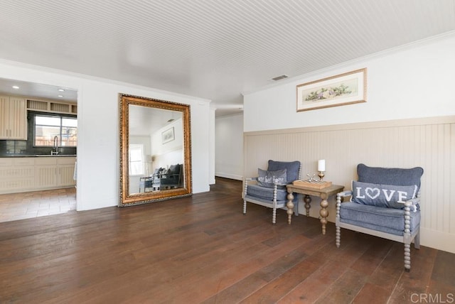 sitting room featuring crown molding, dark hardwood / wood-style floors, and sink