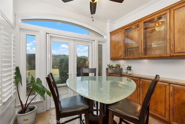 dining space featuring ornamental molding, light tile patterned flooring, and ceiling fan