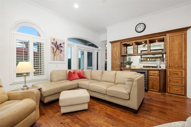 living room featuring crown molding, beverage cooler, dark hardwood / wood-style floors, and bar area