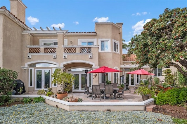 back of house featuring a patio, a balcony, and french doors