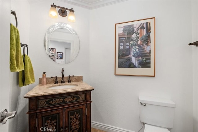 bathroom featuring vanity, ornamental molding, and toilet