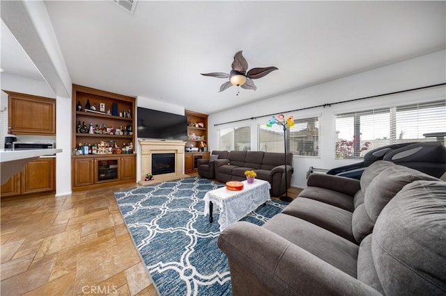 living room featuring wine cooler, ceiling fan, and a healthy amount of sunlight